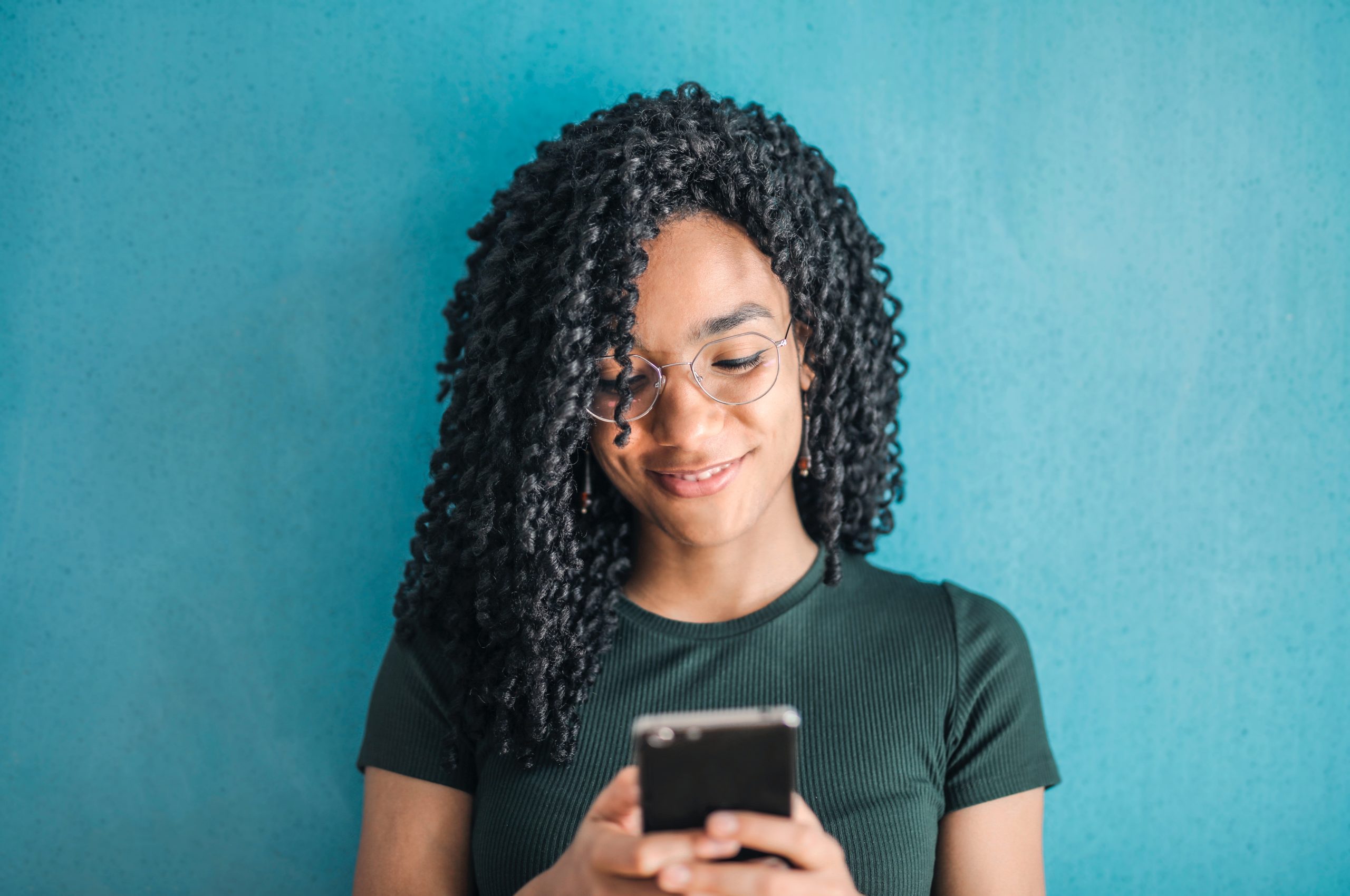 Photo by Andrea Piacquadio: https://www.pexels.com/photo/portrait-photo-of-smiling-woman-in-black-t-shirt-and-glasses-using-her-smartphone-3769022/